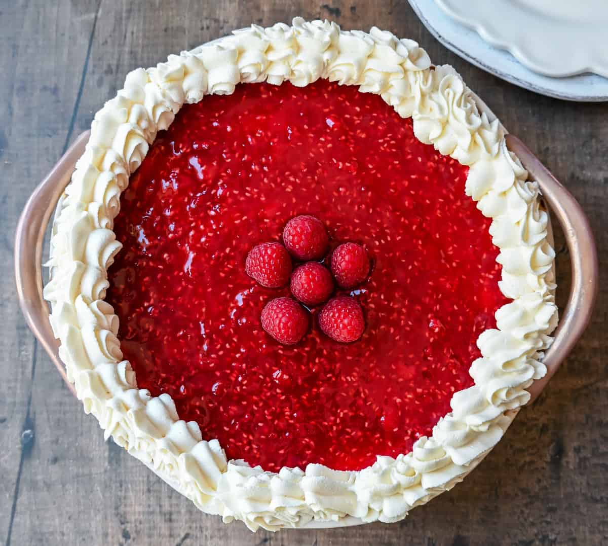 This Homemade Raspberry Cream Pie is made with a sweet luscious cream cheese filling and topped with a homemade raspberry sauce all in a homemade crust. This No-Bake Raspberry Cream Cheese Pie will become one of your absolute favorites!
